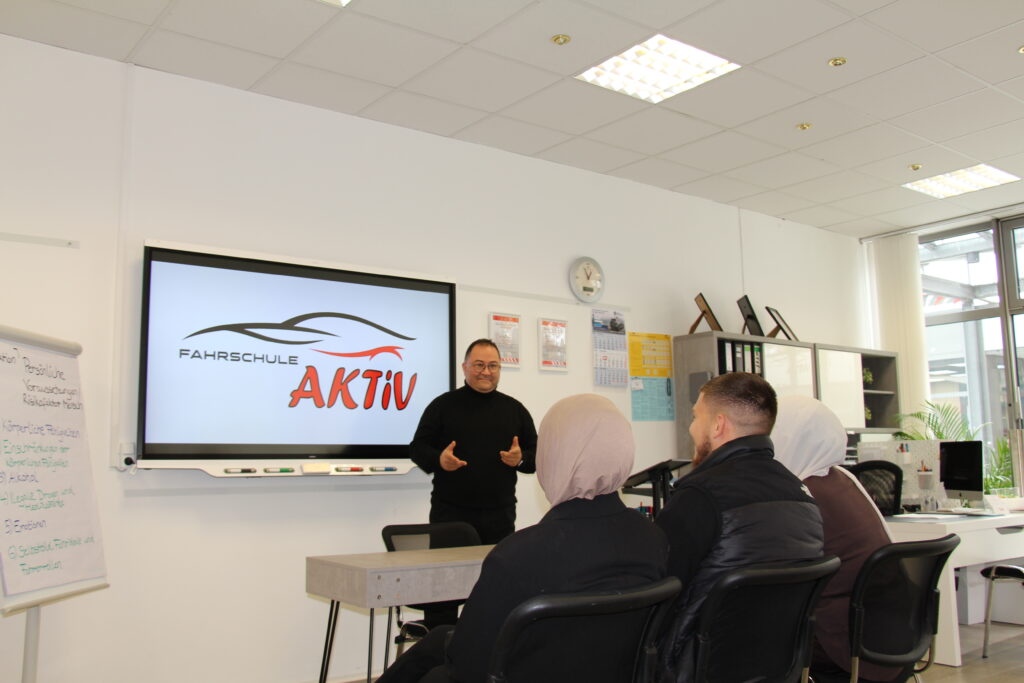 Fahrschülerin trainiert mit Fahrlehrer, Ablenkung am Steuer zu vermeiden und konzentriert zu bleiben in Hamburg